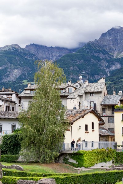 Vom römischen Garten hinter dem Teatro Romano blickt man über uralte Häuser in Richtung Berge.