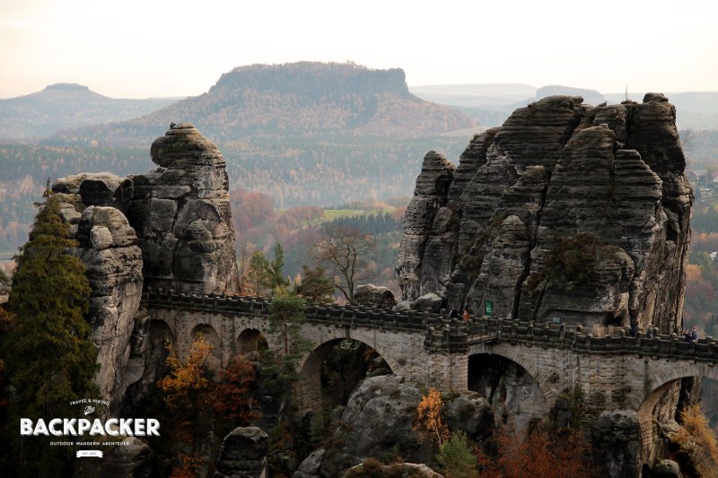 Die über die Felsen laufende Basteibrücke. Im Hintergrund der Lilienstein.